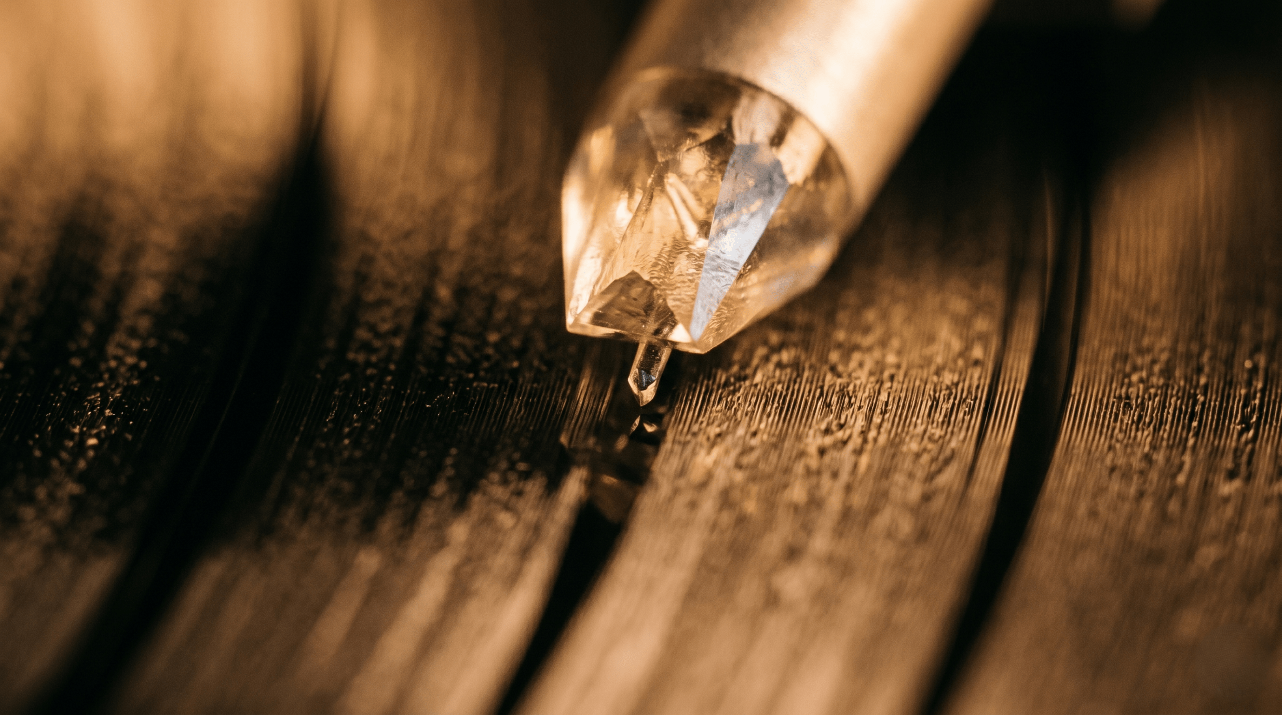 Close-up of a turntable stylus playing a black vinyl record groove in a warm, relaxed setting.