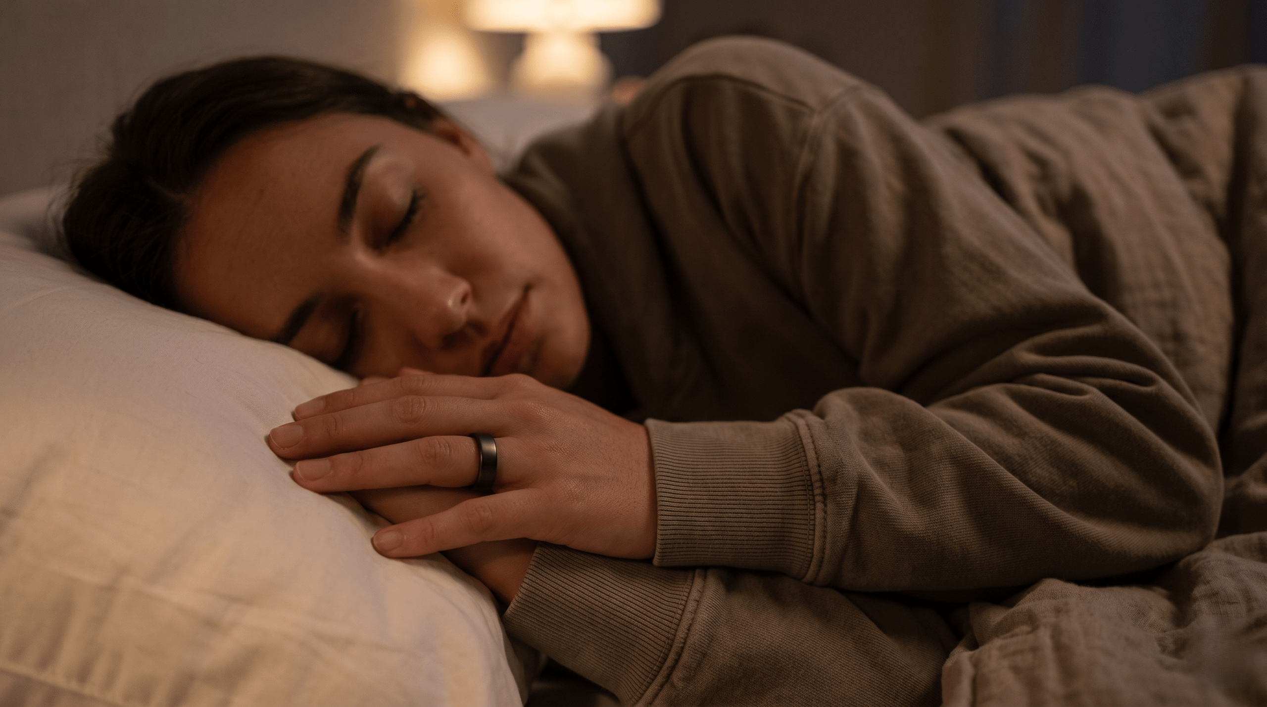 Close-up of a person wearing a sleep tracking ring and a soft valley dreams hoodie sleeve for deep sleep experiment.
